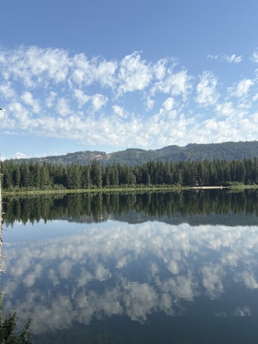 Altocumulus floccus creating layers of reflection by way of Round Lake, Idaho, US