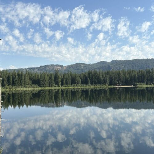 Altocumulus floccus creating layers of reflection by way of Round Lake, Idaho, US