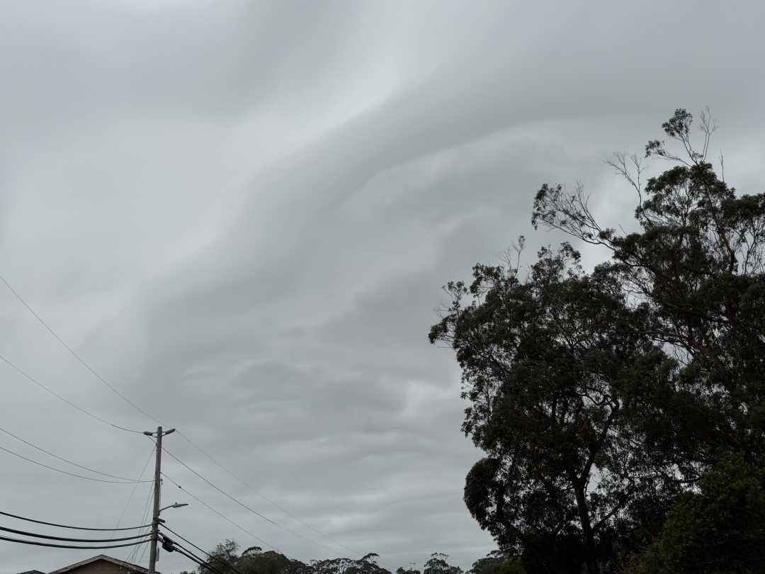 Overcast sky with clouds that arc over the sky.