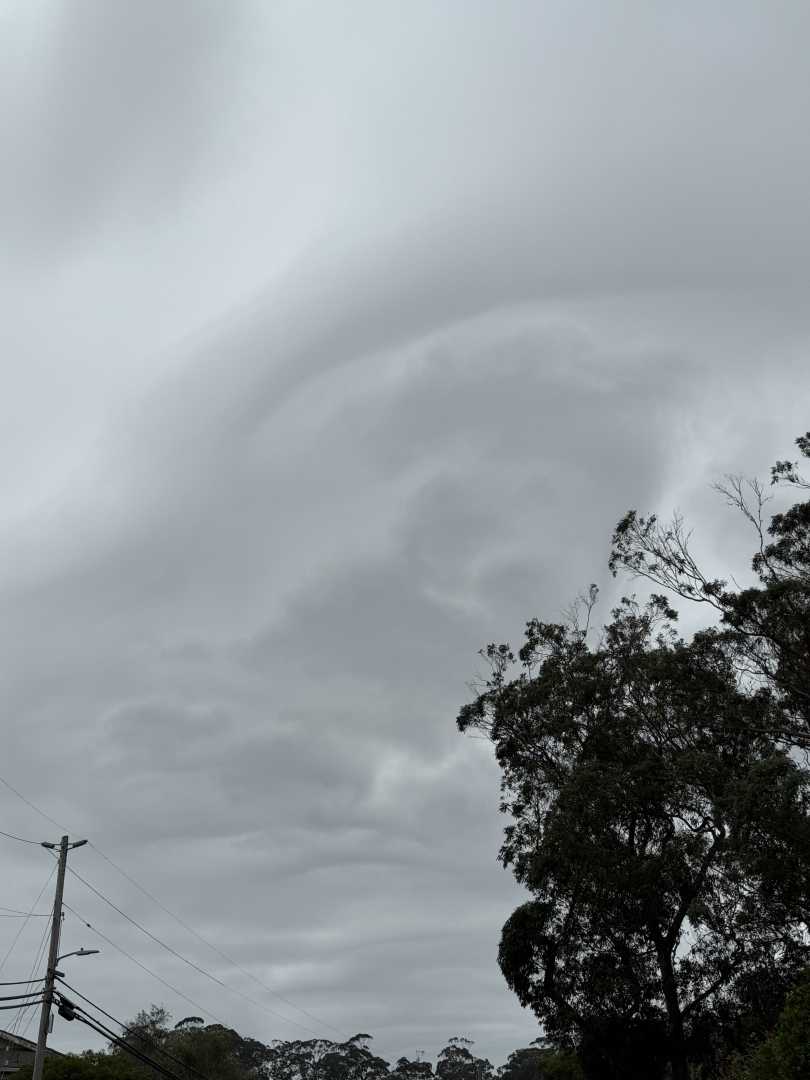 Overcast sky with clouds that arc over the sky.